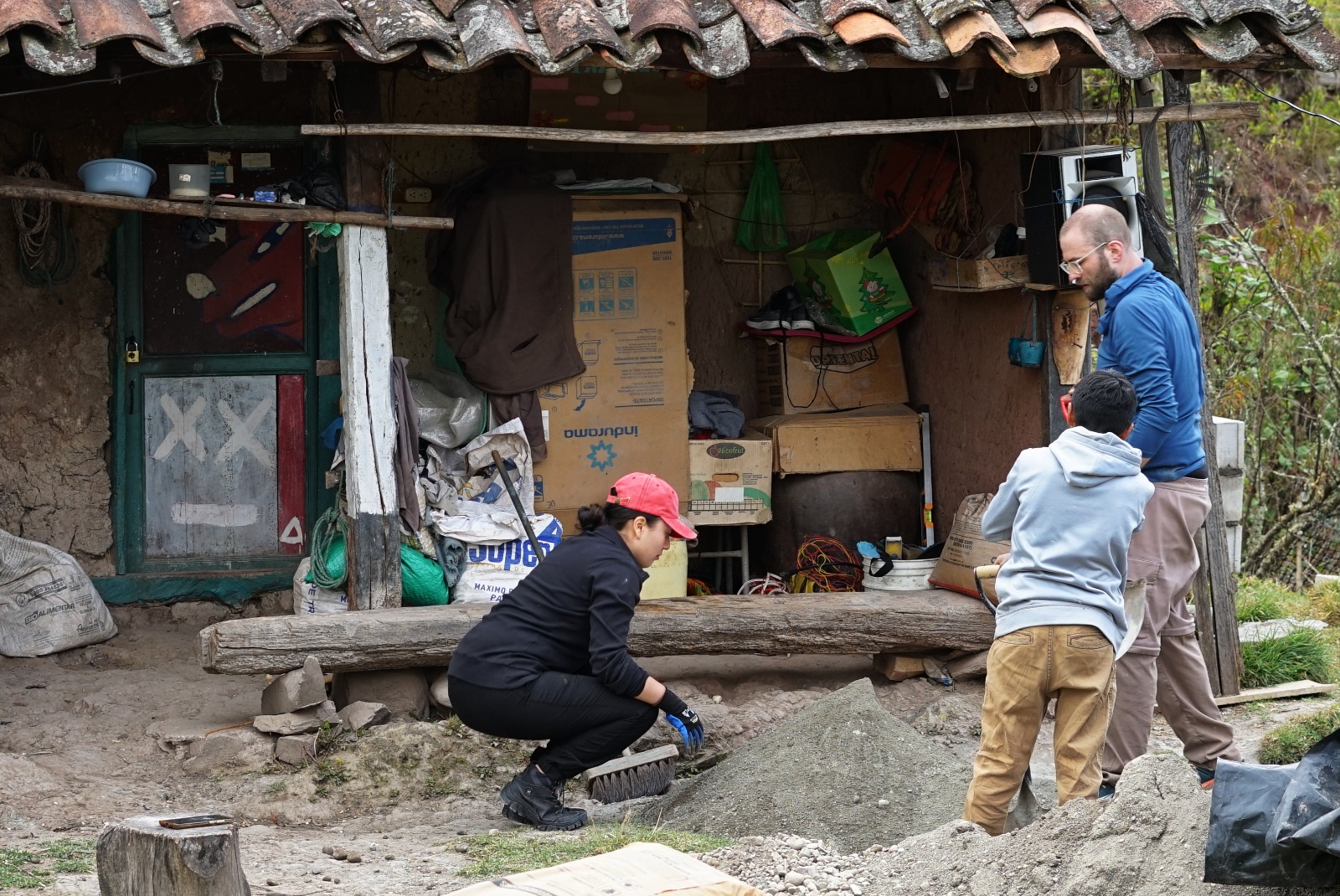 Volunteers mix cement outside a home in Jadán