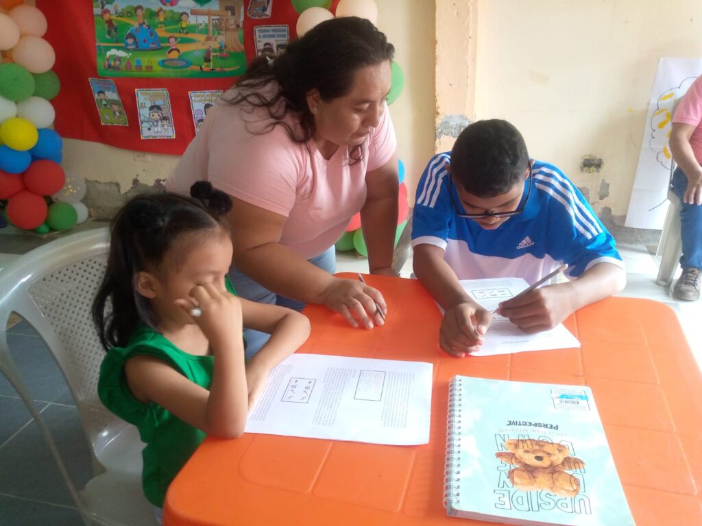 A tutor works with two Nomads Scholars students