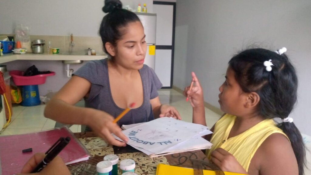 A tutor working through a worksheet with a young student in Nueva Prosperina